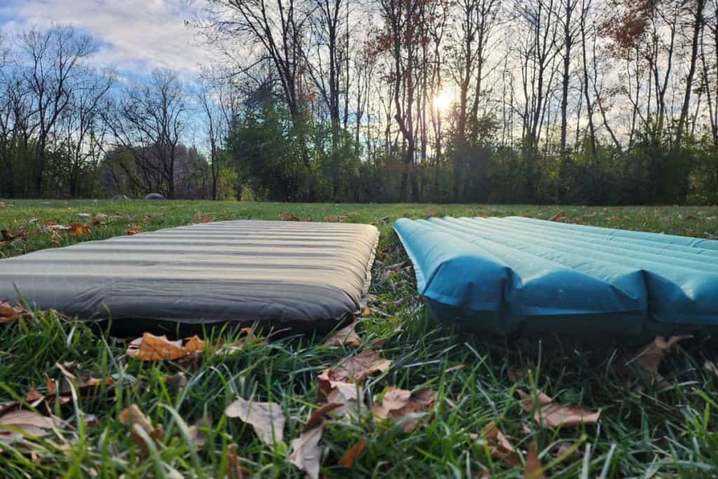 a gray and blue sleeping pad on the grass
