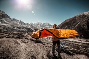 man holding out his sleeping bag