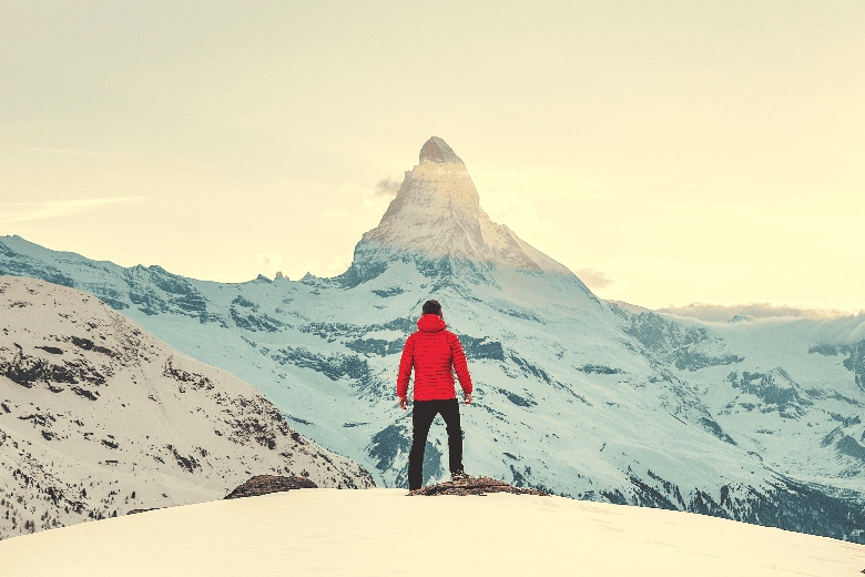man using layering system in front of matterhorn