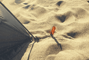 tent stake buried in the sand