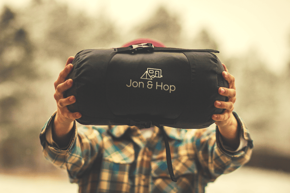 man holding a jon and hop sleeping bag in his hands