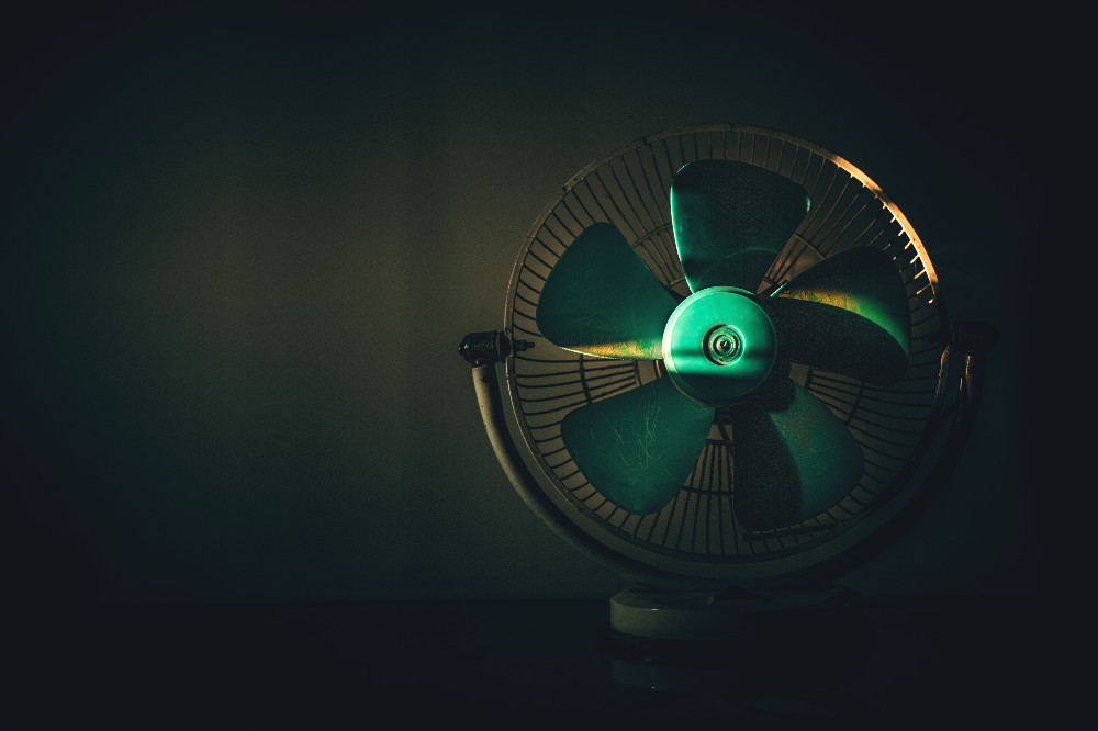 fan sitting on a desk in the dark