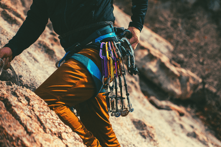 person climbing with a rack of camelots