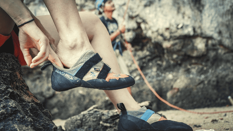 person putting climbing shoes on