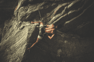 man rock climbing shirtless