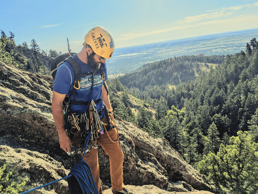 man holding a rope with a rack of gear