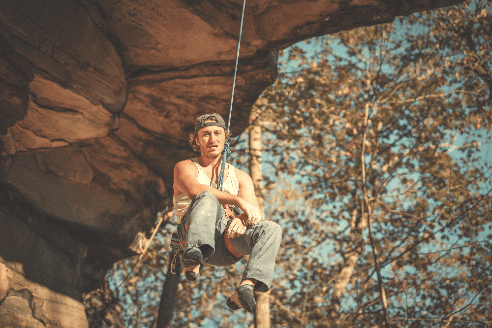 man hanging from a climbing rope