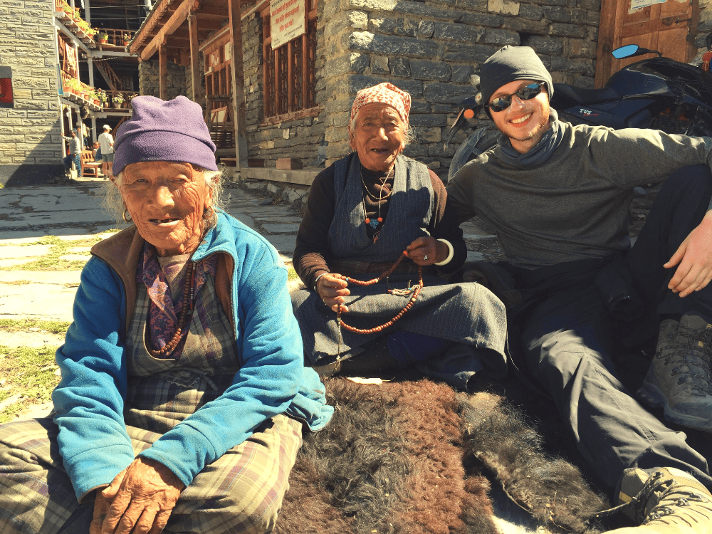 man and two women sitting on a yak pelt