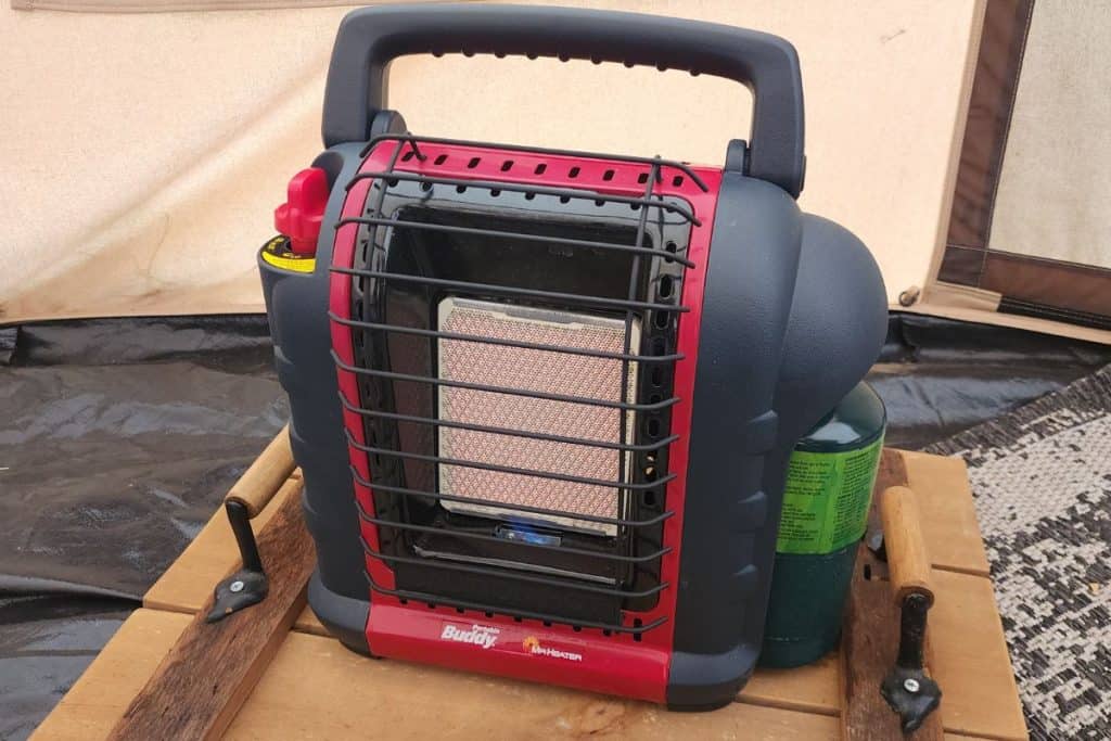 red and black tent heater on a wood platform