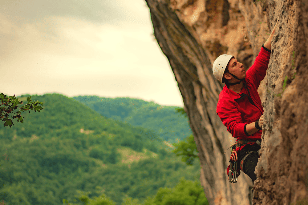 man rock climbing while wearing a helmet
