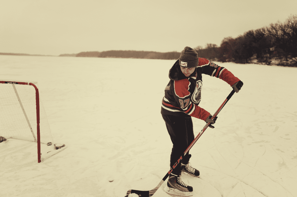 man playing hockey on a lake