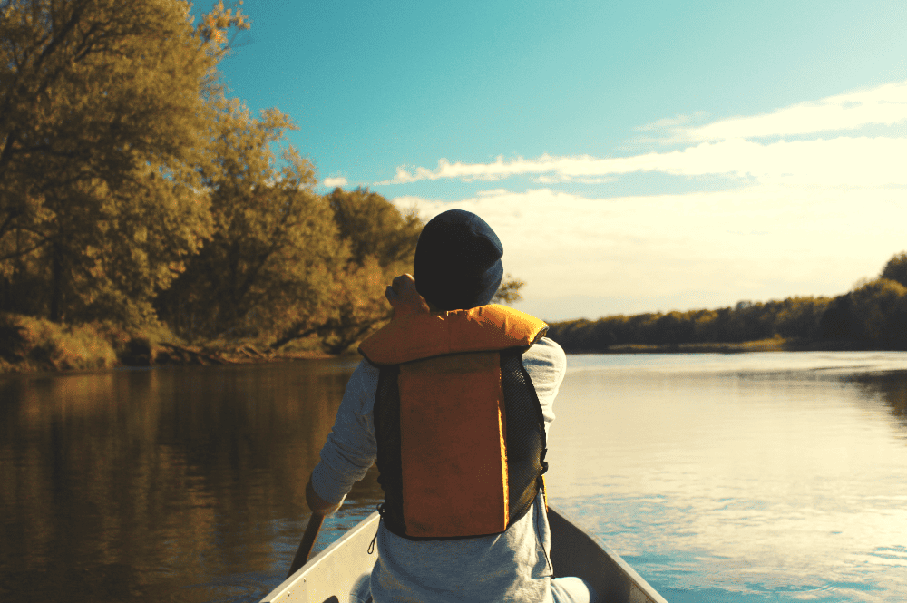 person sitting in a canoe on a lake