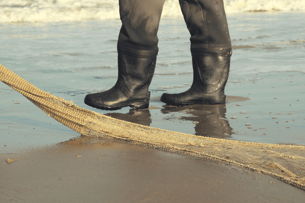 person wearing boots in the ocean