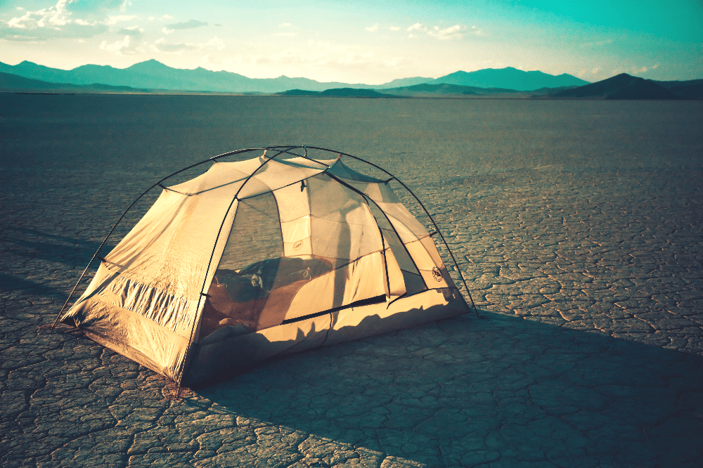 tent pitched on cracked desert land