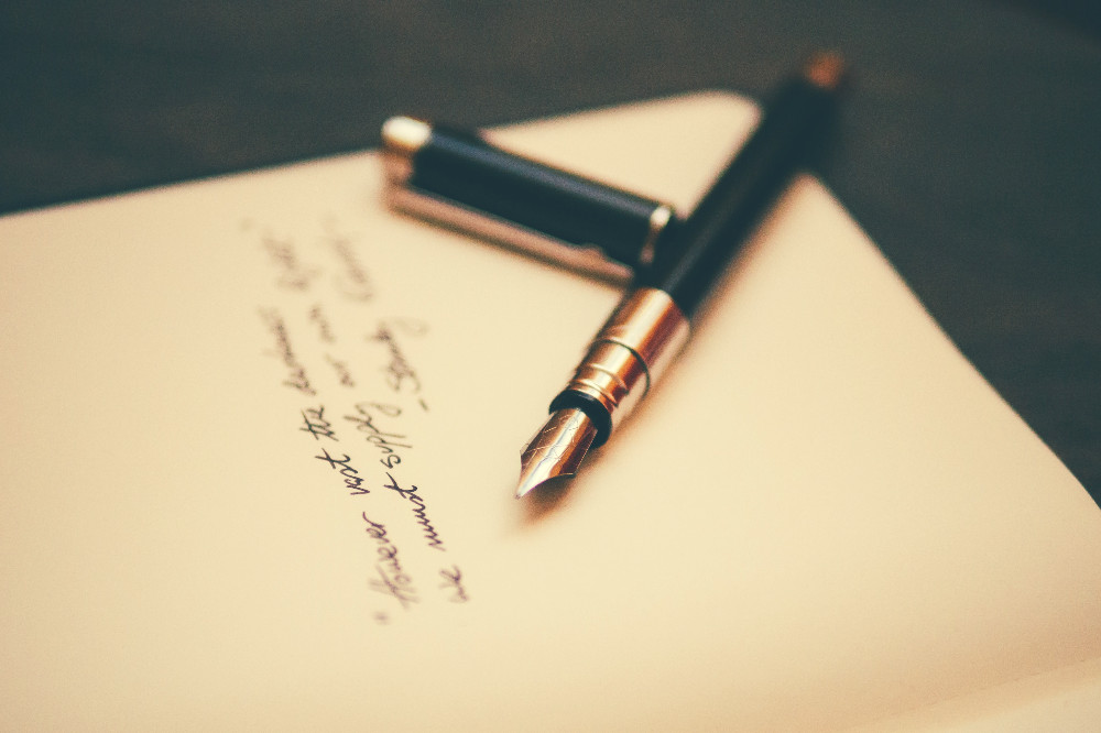 fountain pen on a journal with text on it