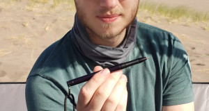 man holding a pen in a tent in the desert