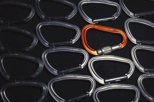 carabiners lined up next to each other on a black background