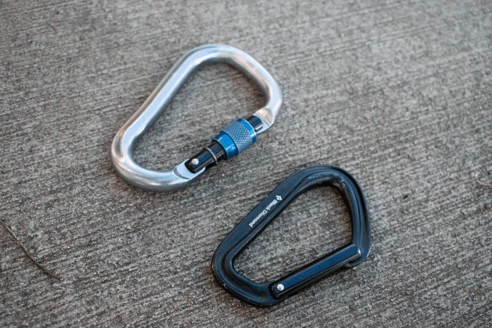 a locking and non locking carabiner next to each other on the sidewalk