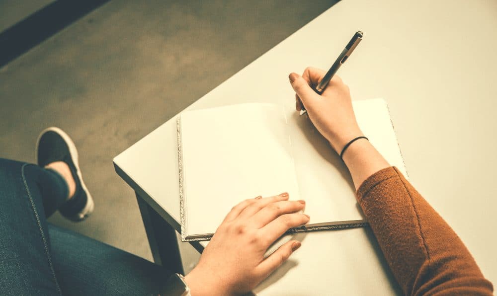 woman holding a pen while journaling
