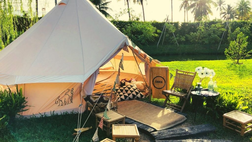 canvas tent on a grass lawn with a bed inside