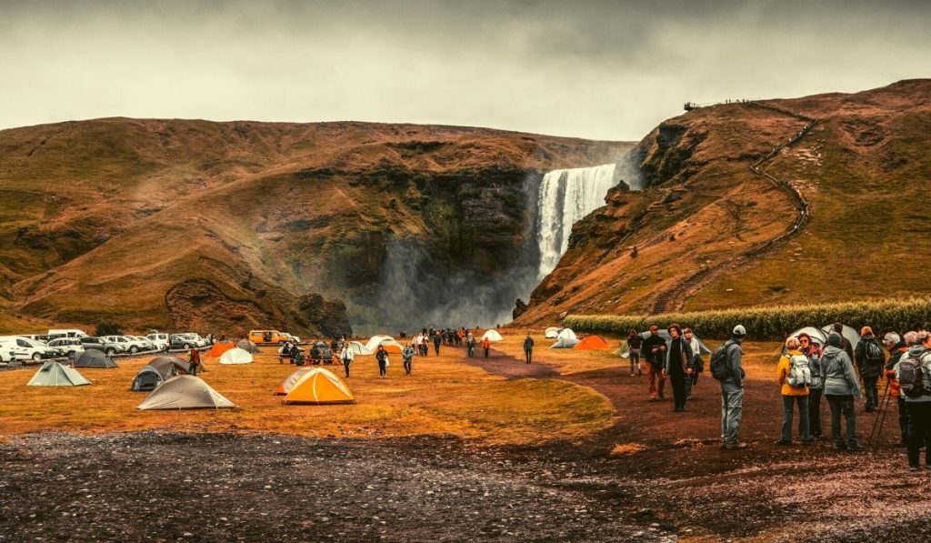 several tents pitched next to a waterfall