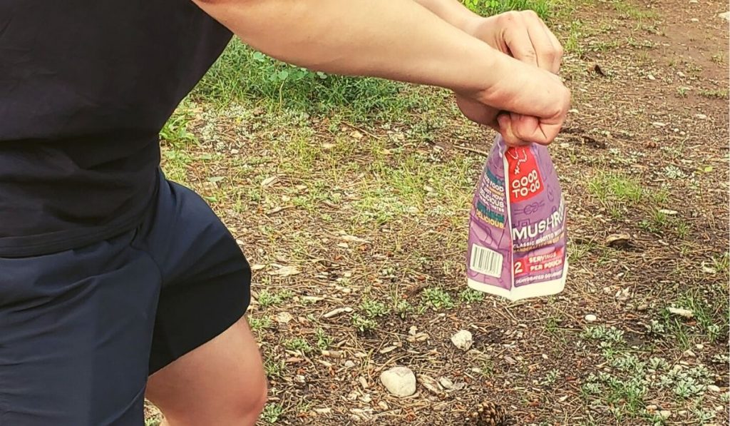 man holding a bag of dehydrated food while camping
