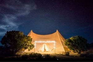 large canvas tent with lights strung on it at night