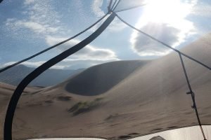 looking through the mesh tent at an open desert with mountains