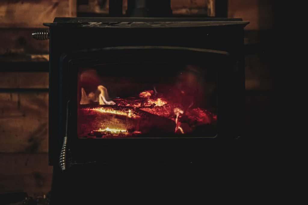 wood stove with burning logs in a cabin