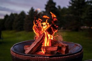 wood logs on fire in a metal pan