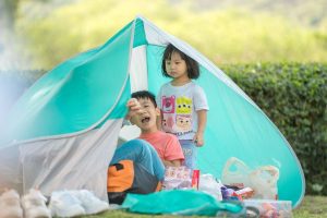 two kids playing in a blue tent