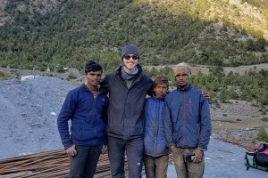 four men standing next to each other by logs