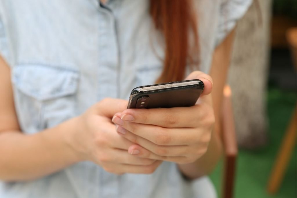 woman holding smartphone outside