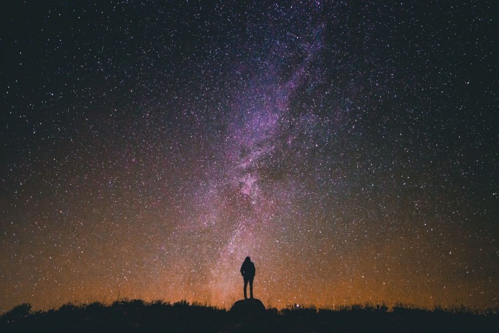 person standing under a night sky with the milky way