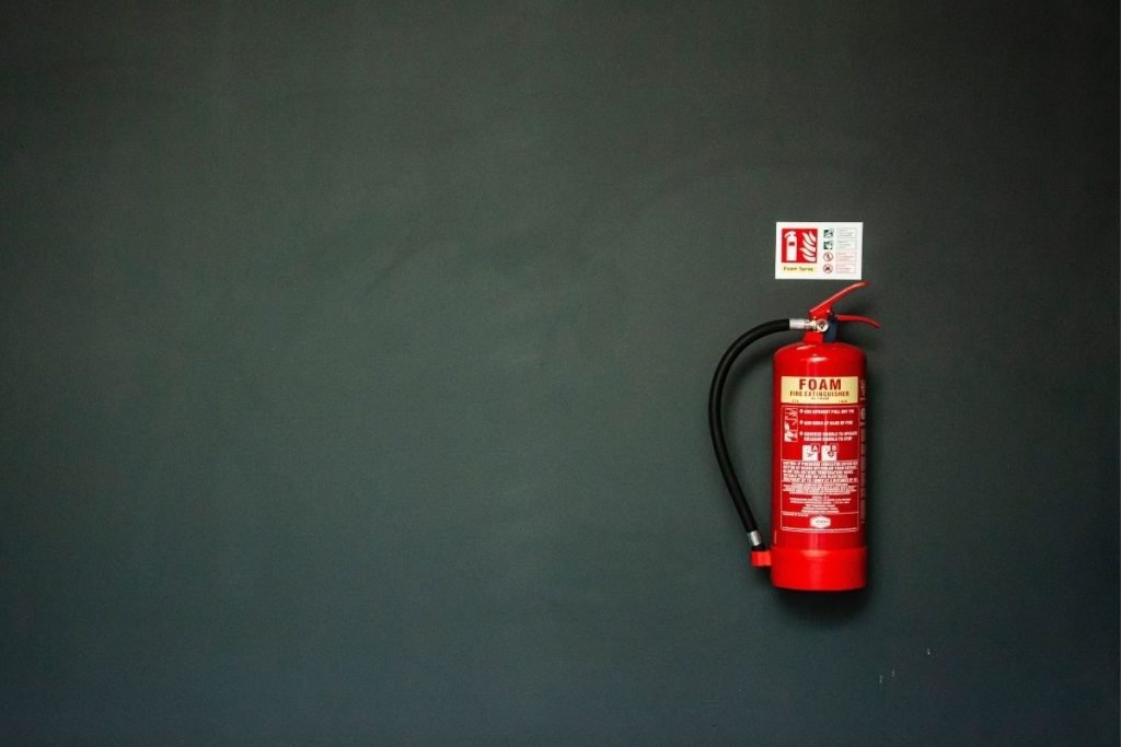 red fire extinguisher on a gray wall