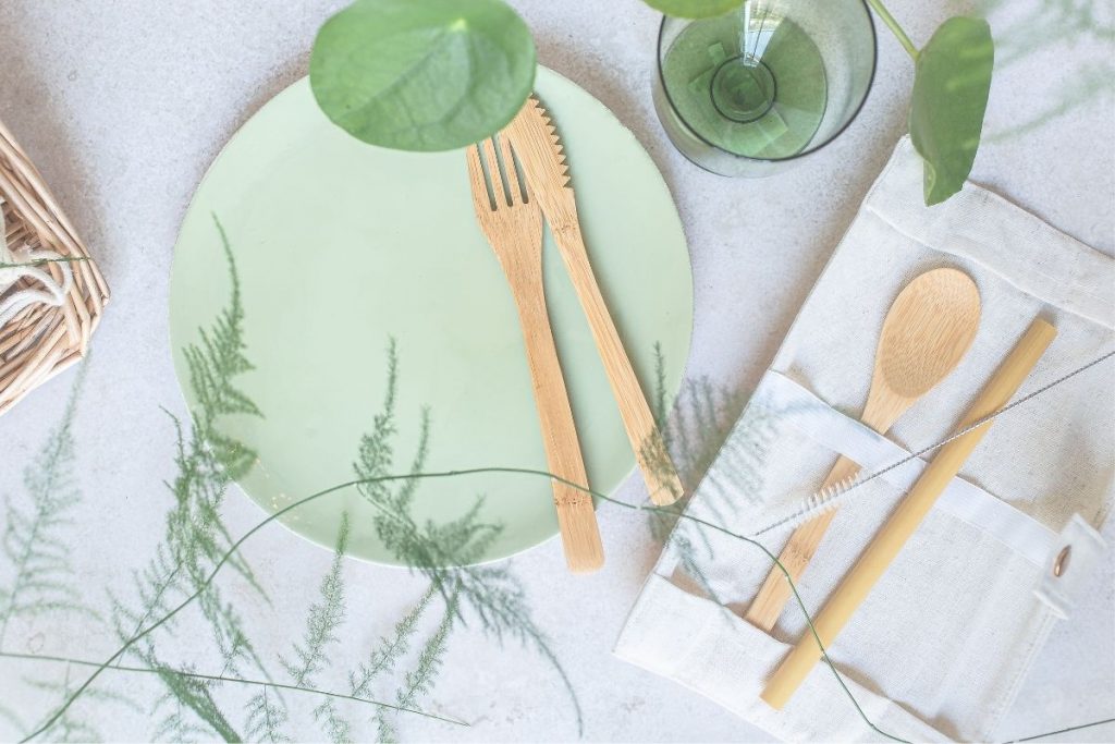 wooden utensils on a green plate and white table