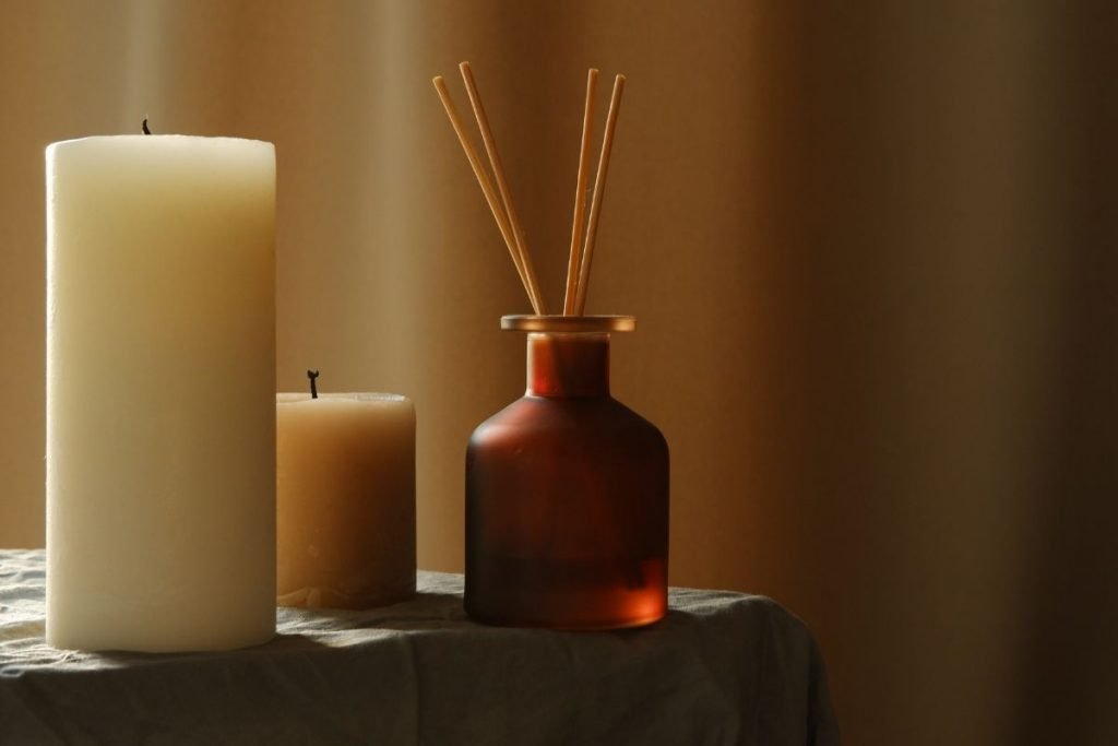 two candles and incense on a table