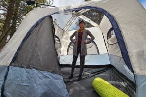 woman standing up inside of a tent