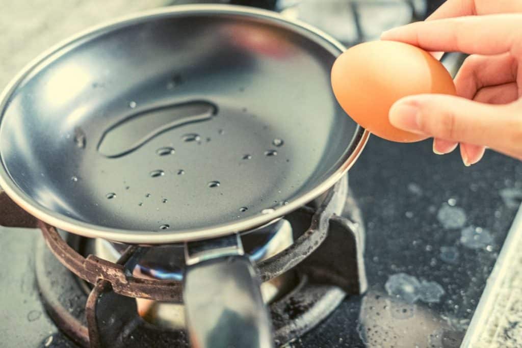 egg over a frying pan with oil