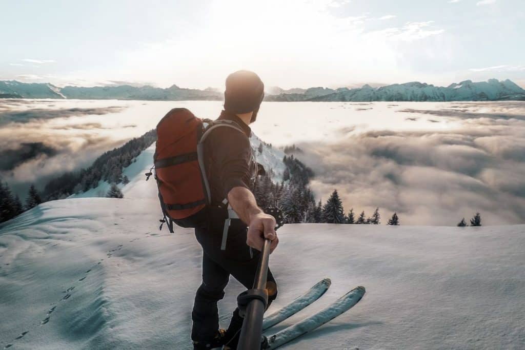man on skis with backpack on snowy mountain