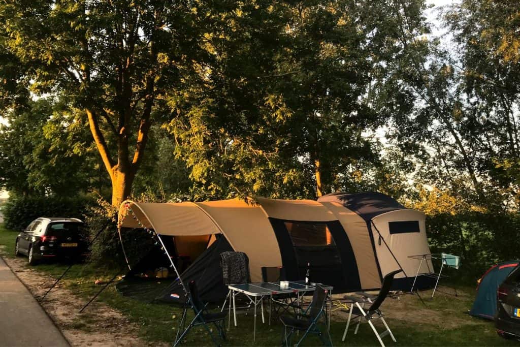 large tent next to trees and car