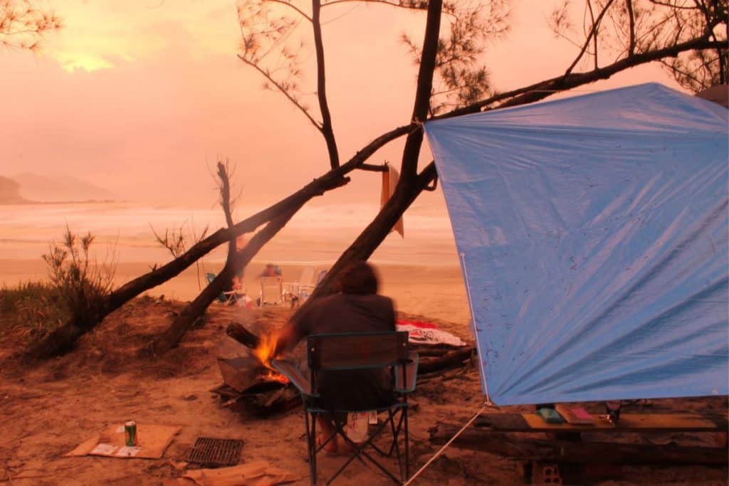 blue tarp hung in the air with person sitting in chair