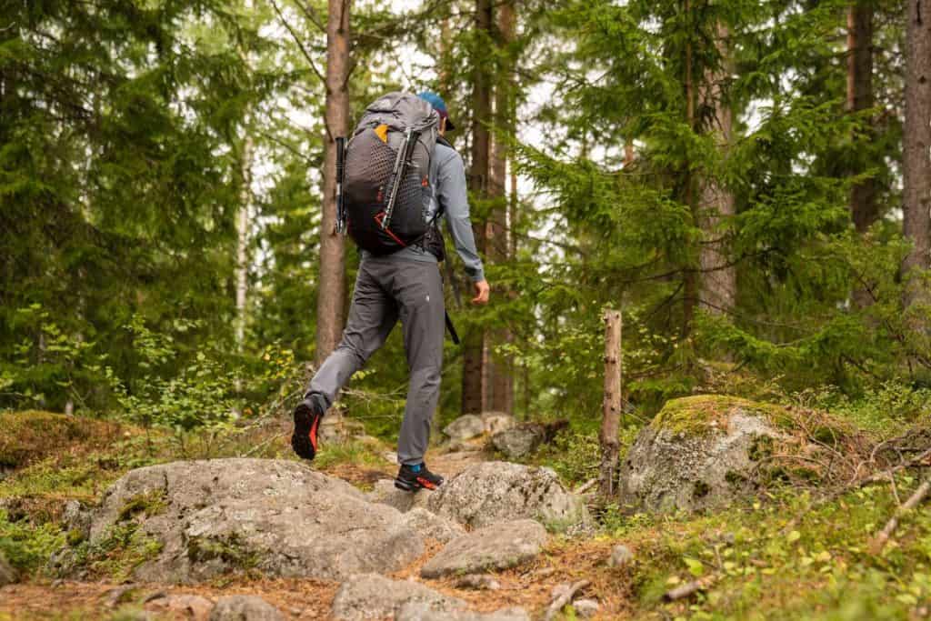 person hiking with backpack through the forest