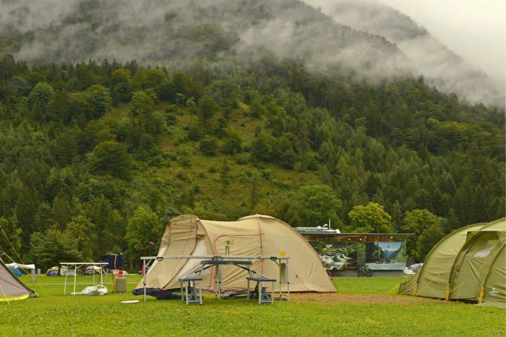 tan tent next to other tents in the mountains
