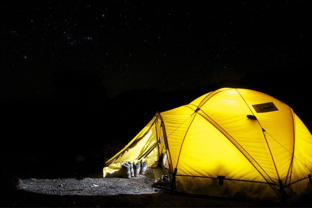 yellow tent with a light on at night