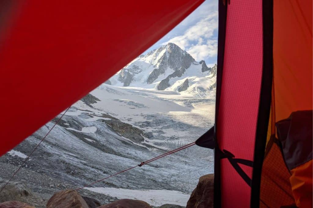 red tent door looking at snowy mountains