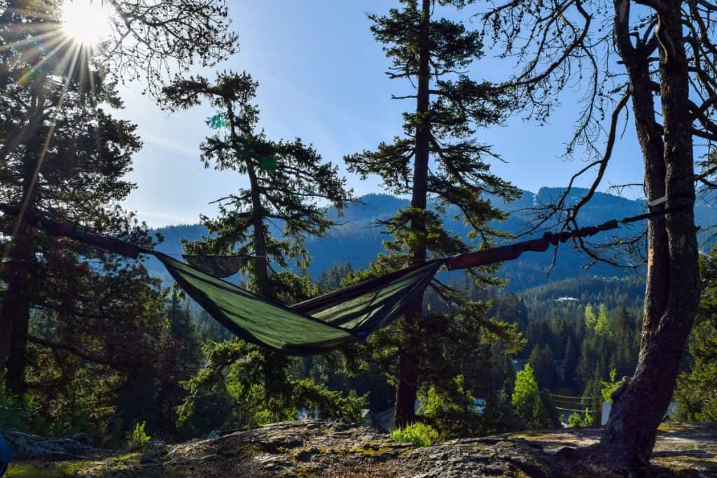 green hammock between trees in the mountains