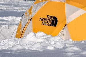yellow north face tent in snow