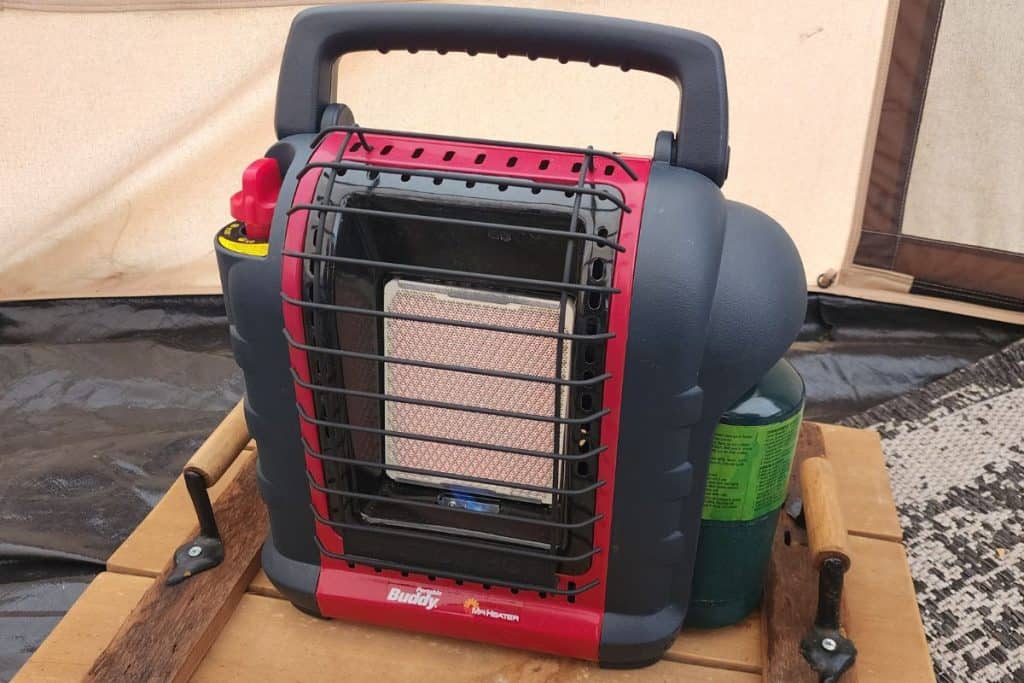 red and black tent heater on a wooden platform