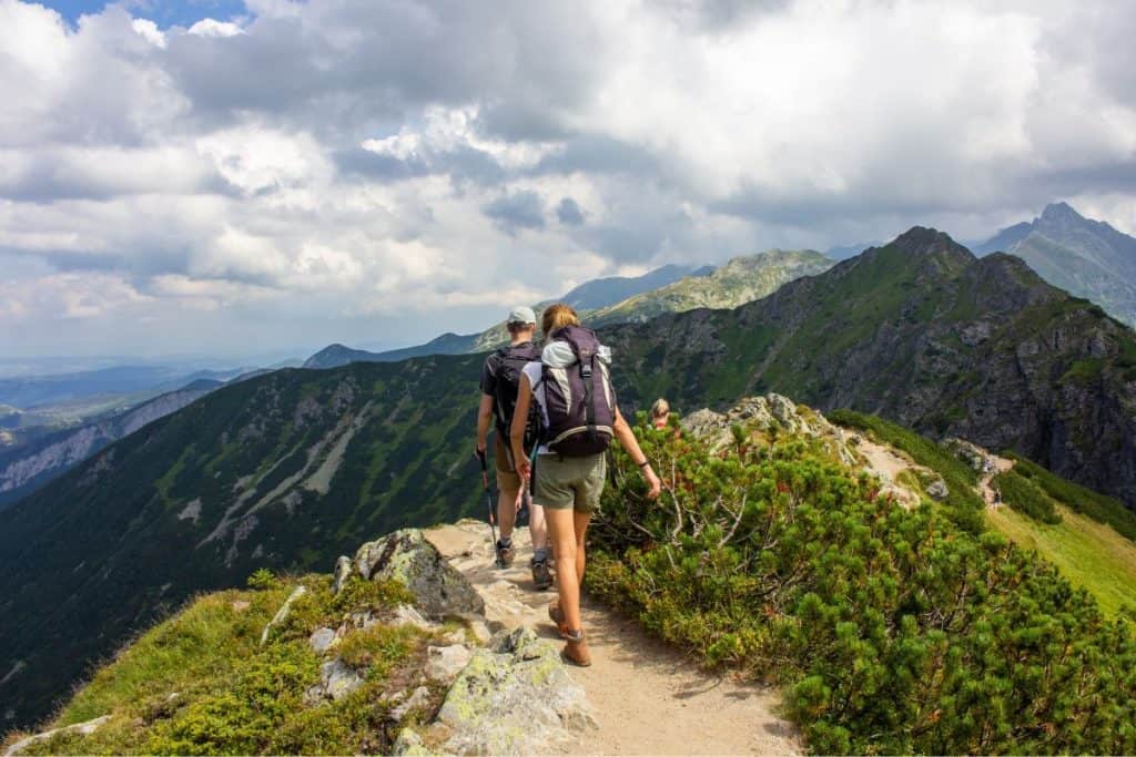 man and woman hiking on a mountain ridge